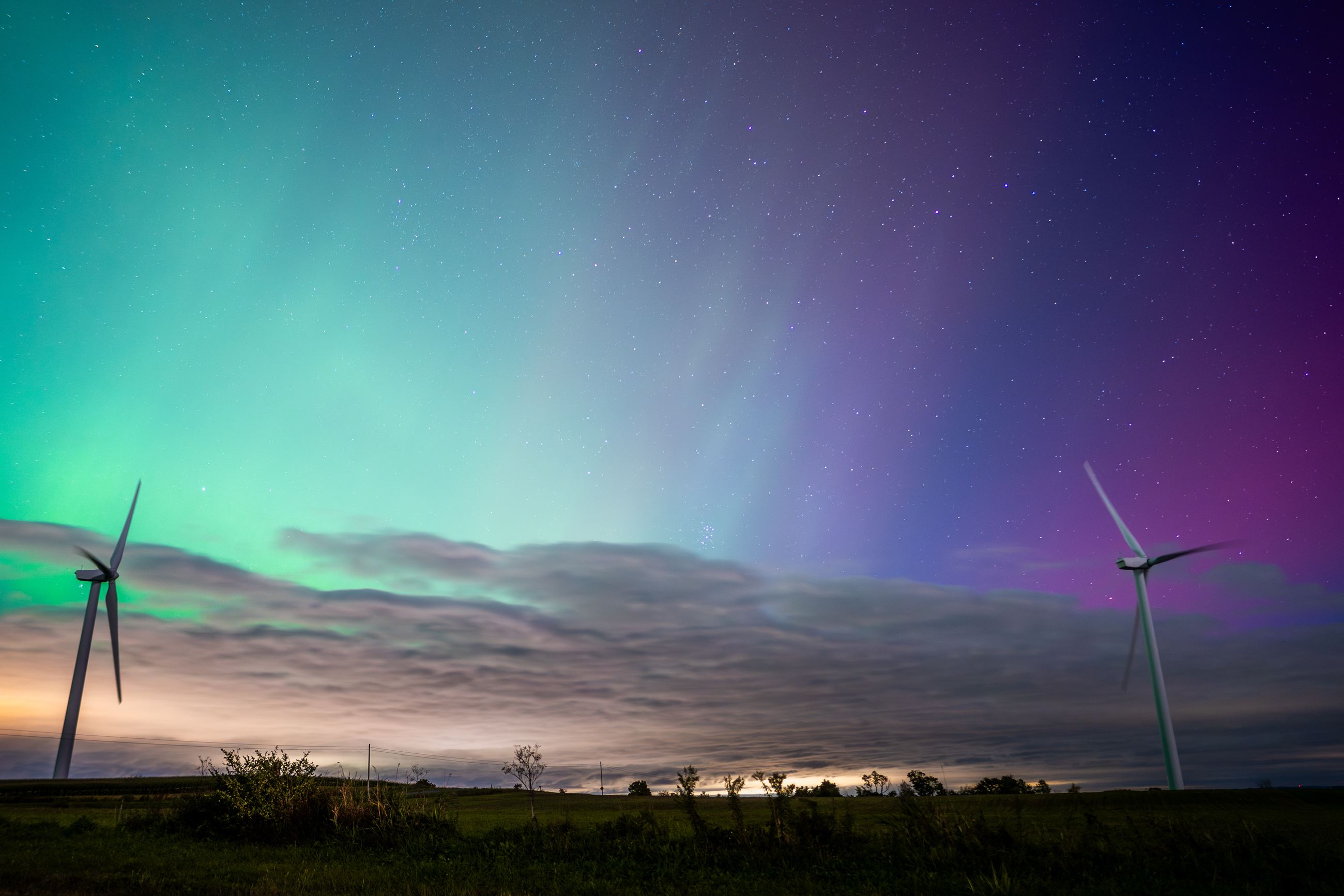 Picture taken by D. Adams of the northern lights illuminating the sky behind a few windmills. 