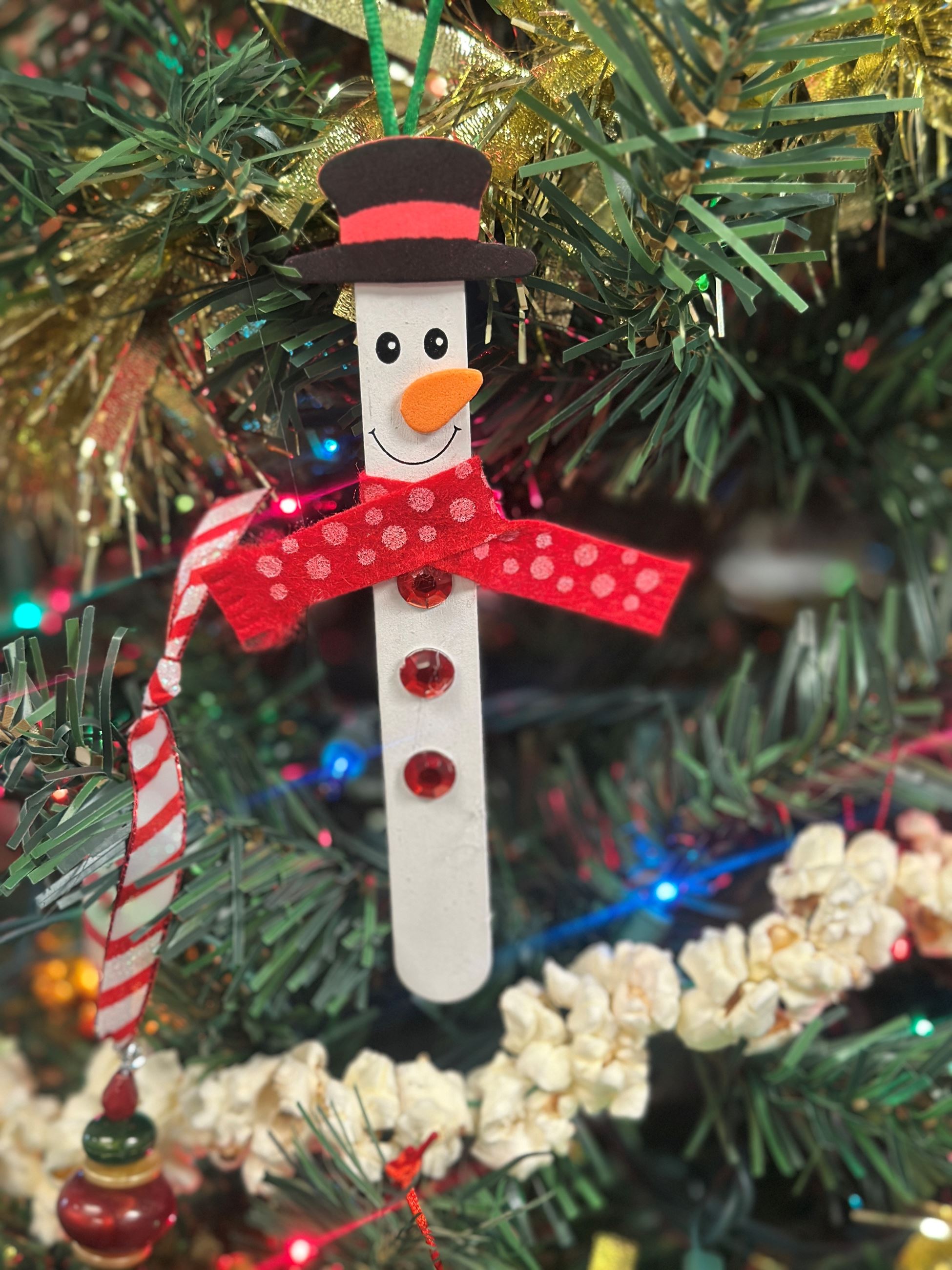 Close up of Christmas tree and popsicle stick snowman ornament