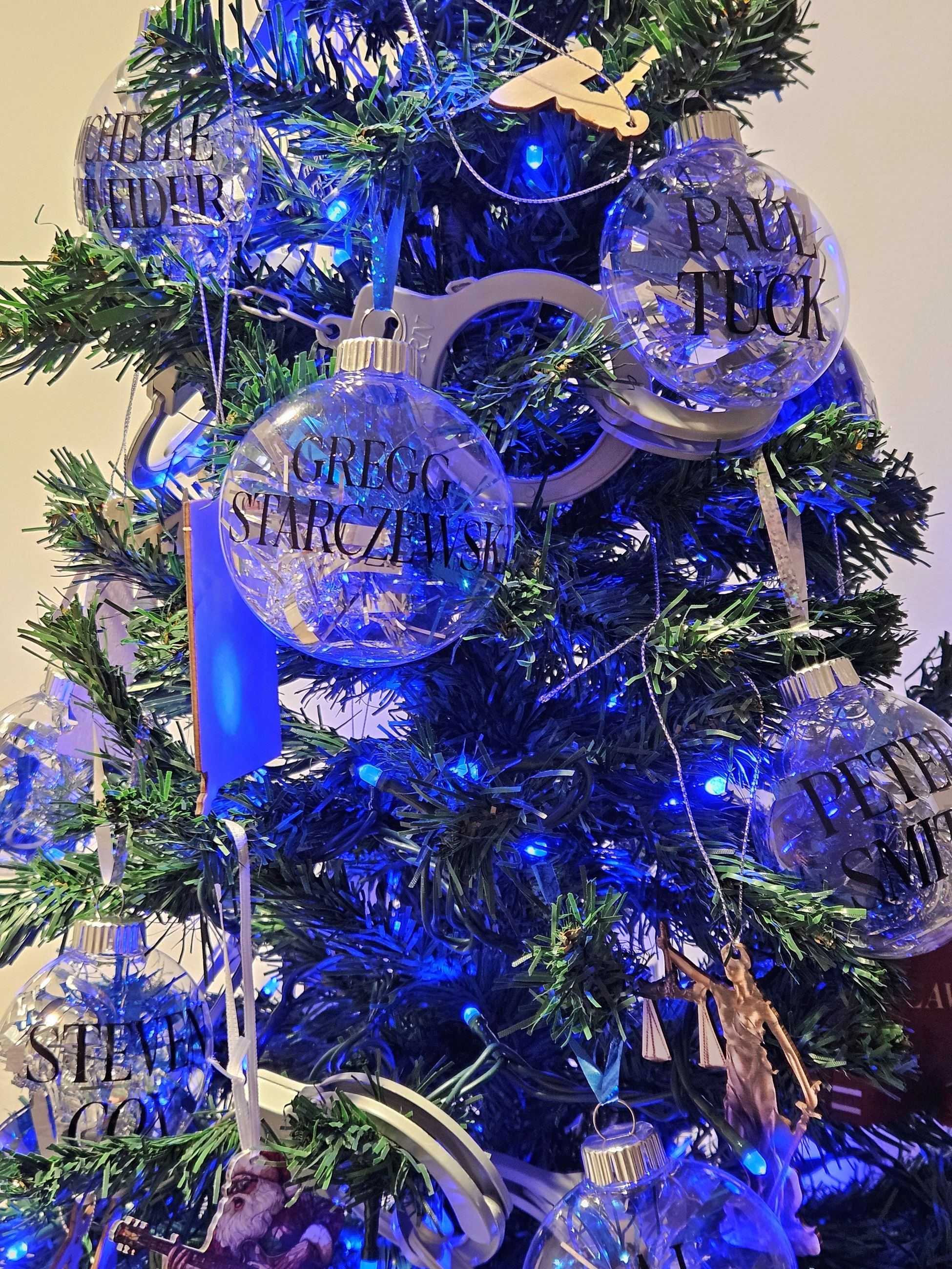 Close up of ornaments on blue lit tree