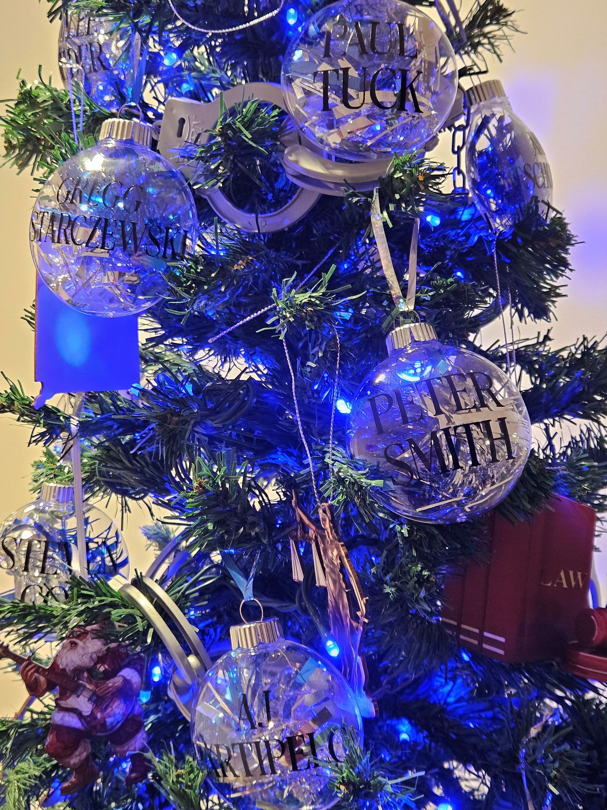 Close up of ornaments on blue lit tree